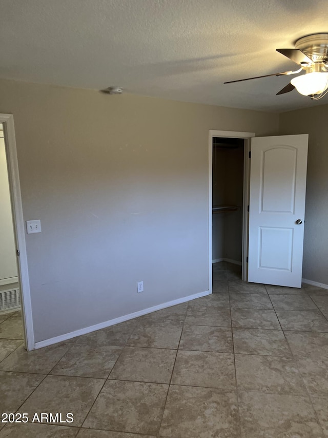 unfurnished bedroom with a closet, visible vents, a ceiling fan, a textured ceiling, and baseboards