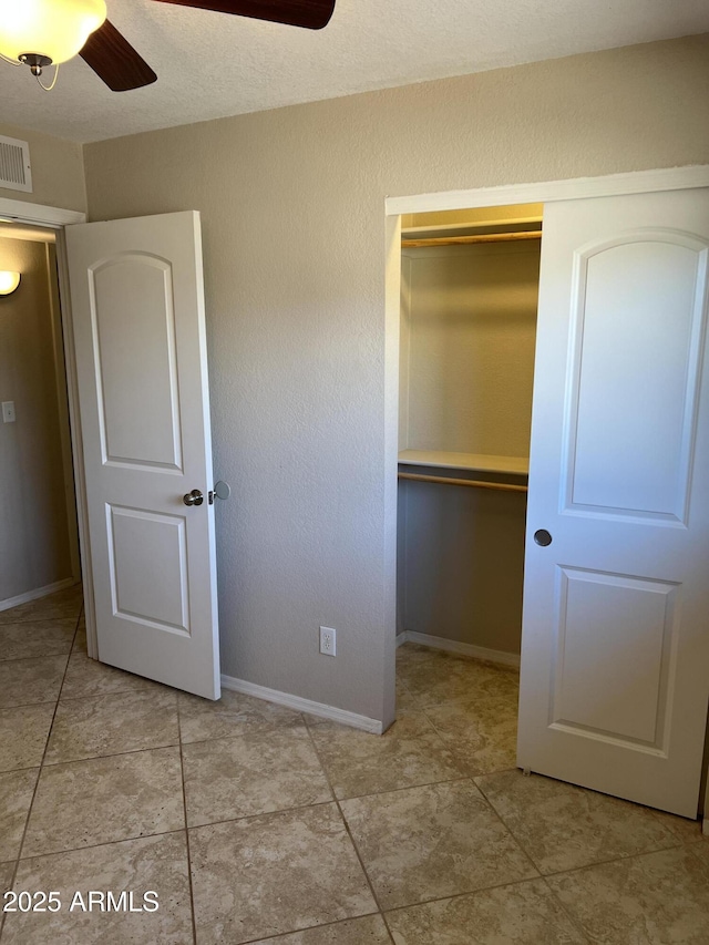 unfurnished bedroom featuring a ceiling fan, baseboards, visible vents, and a closet