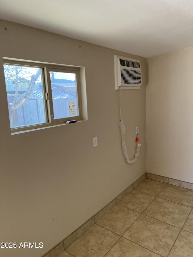 washroom with light tile patterned floors, a wall mounted air conditioner, and baseboards