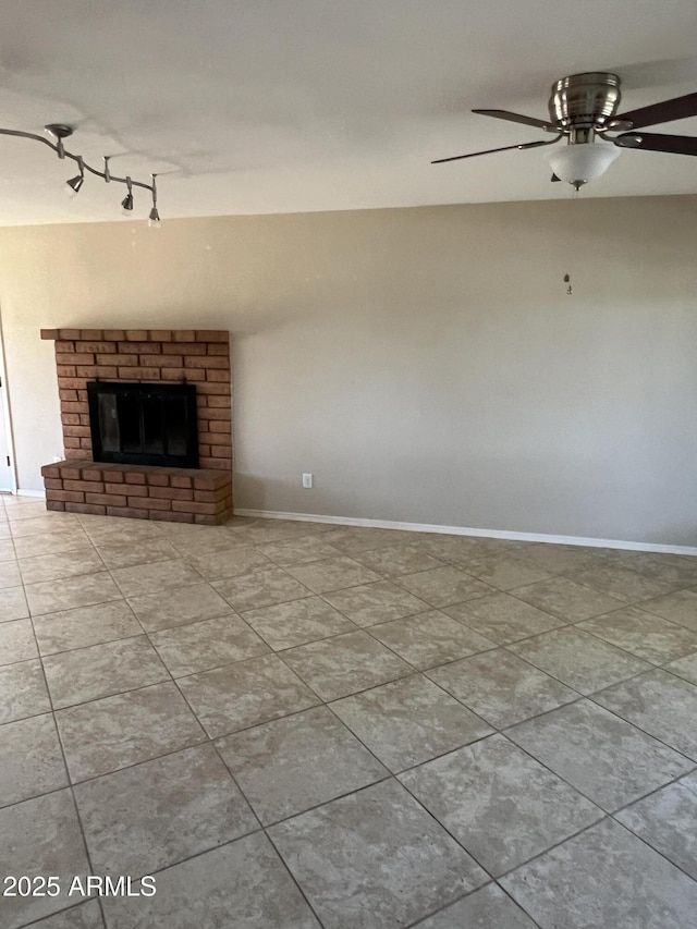 unfurnished living room with a fireplace, baseboards, and tile patterned floors