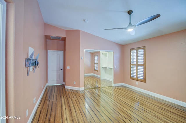 empty room featuring ceiling fan, vaulted ceiling, and light hardwood / wood-style floors