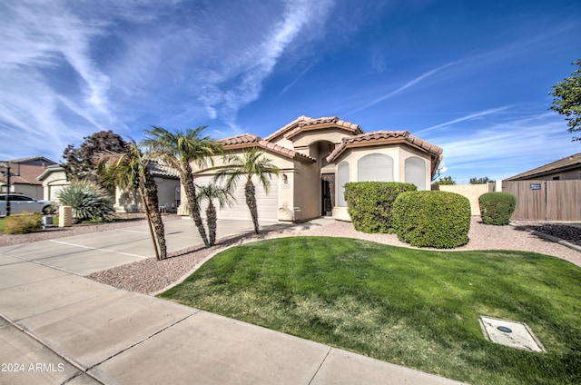 mediterranean / spanish-style home featuring a front yard and a garage