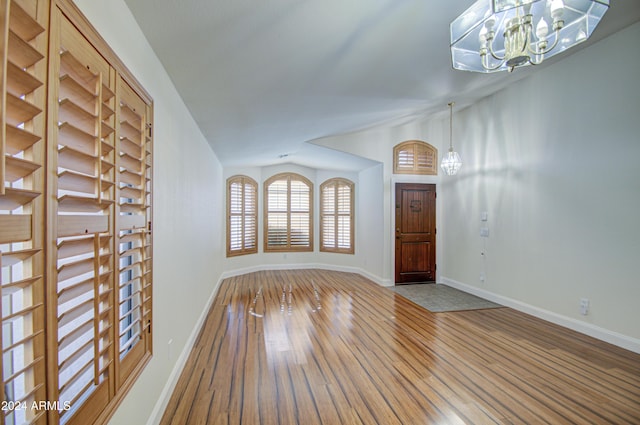 interior space featuring a chandelier, lofted ceiling, and hardwood / wood-style floors