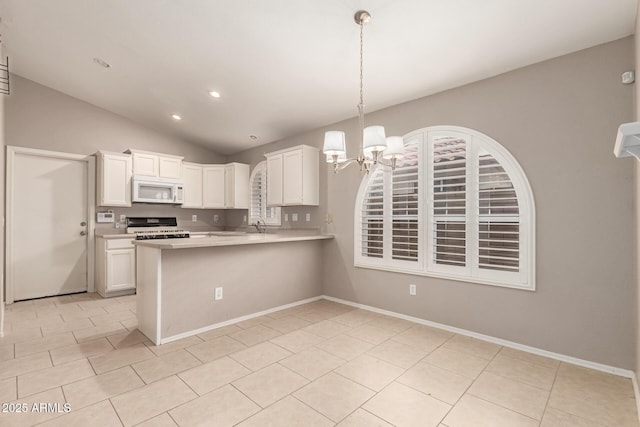 kitchen featuring white cabinetry, hanging light fixtures, gas stove, light tile patterned flooring, and kitchen peninsula