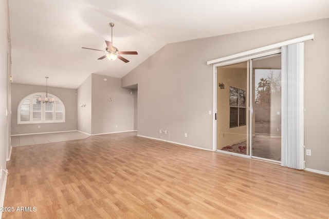 unfurnished living room with lofted ceiling, ceiling fan with notable chandelier, and light hardwood / wood-style flooring