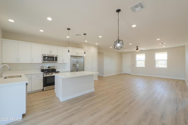 kitchen with visible vents, a center island, stainless steel appliances, a sink, and recessed lighting