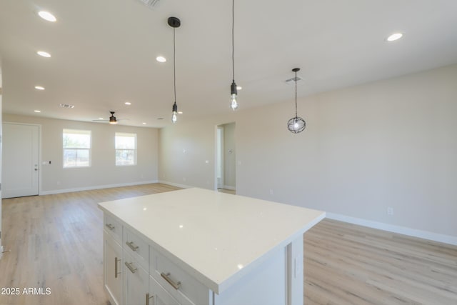 kitchen with recessed lighting, light wood-style flooring, light countertops, and a center island