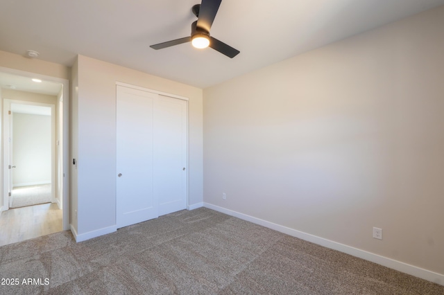 unfurnished bedroom featuring a closet, carpet flooring, ceiling fan, and baseboards