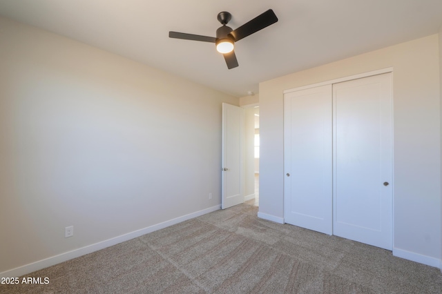 unfurnished bedroom with carpet floors, a ceiling fan, baseboards, and a closet