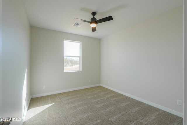 carpeted spare room with baseboards, visible vents, and ceiling fan