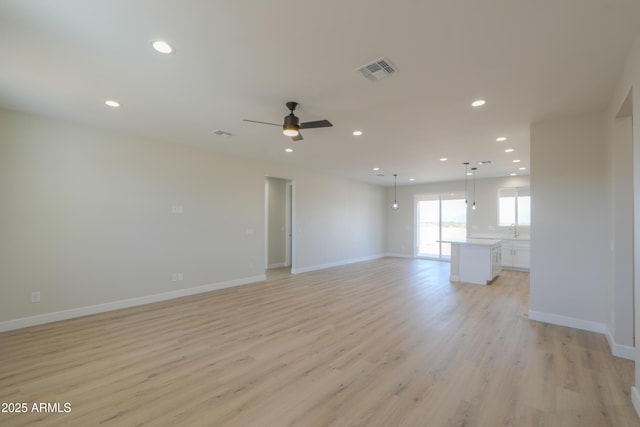 unfurnished living room featuring light wood-style flooring, visible vents, baseboards, and recessed lighting