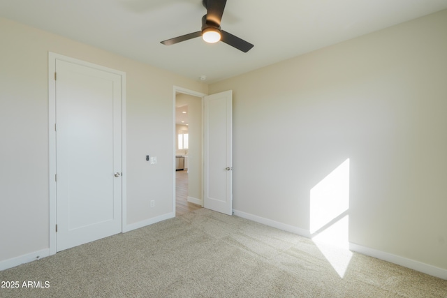 unfurnished bedroom with carpet floors, baseboards, and a ceiling fan