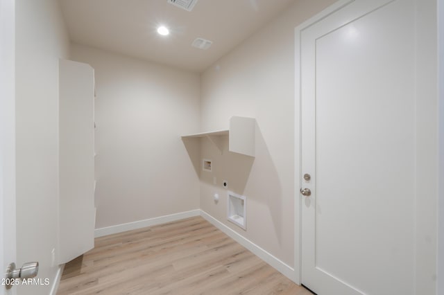 clothes washing area featuring hookup for a washing machine, hookup for an electric dryer, wood finished floors, laundry area, and baseboards