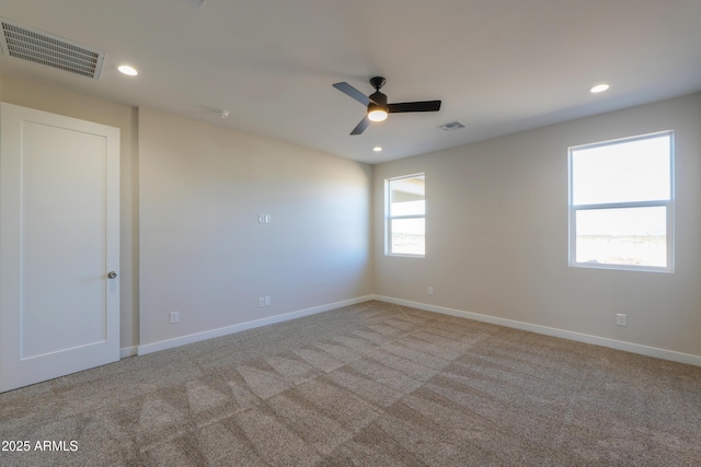 carpeted spare room featuring a ceiling fan, recessed lighting, visible vents, and baseboards