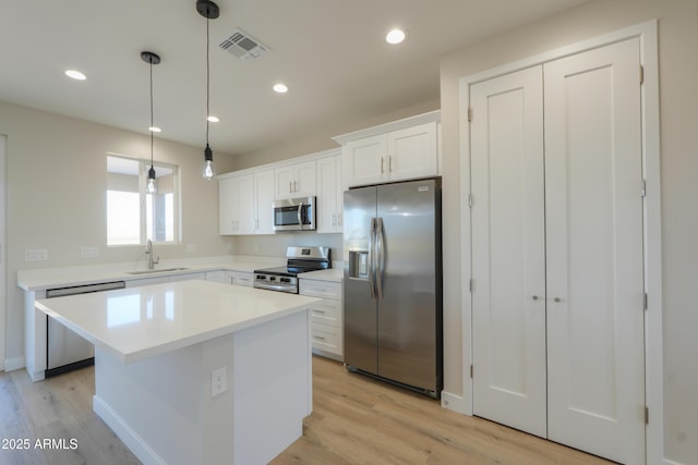 kitchen with visible vents, appliances with stainless steel finishes, white cabinetry, a sink, and recessed lighting