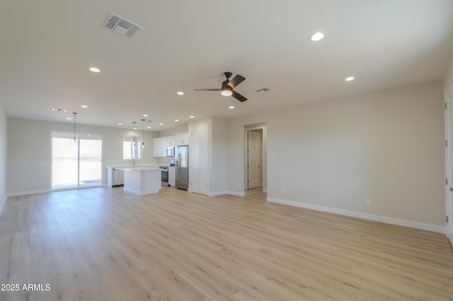 unfurnished living room with light wood finished floors, recessed lighting, visible vents, ceiling fan, and baseboards