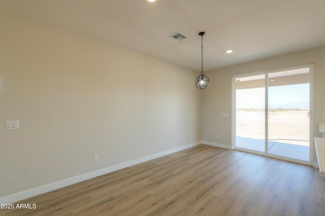 spare room featuring light wood finished floors, baseboards, visible vents, and recessed lighting