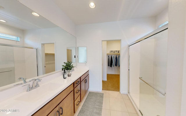 12550 W Luxton Ln, Avondale, AZ 85323 - bathroom featuring double vanity, a walk in closet, a stall shower, tile patterned floors, and recessed lighting