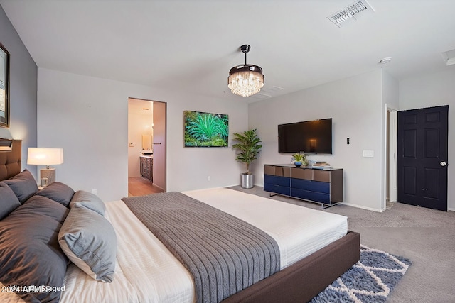 carpeted bedroom featuring connected bathroom and a notable chandelier