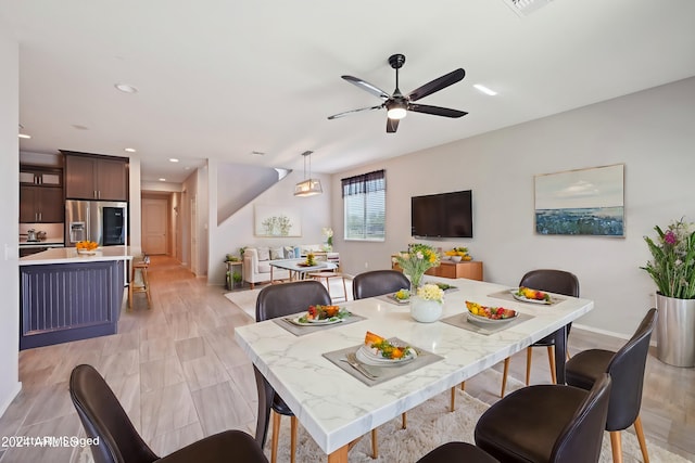 dining space with light wood-type flooring and ceiling fan