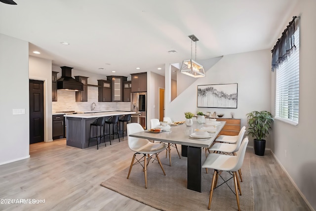 dining area featuring light wood-type flooring and sink