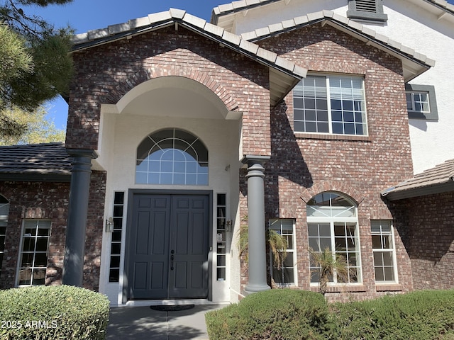 entrance to property with stucco siding and brick siding