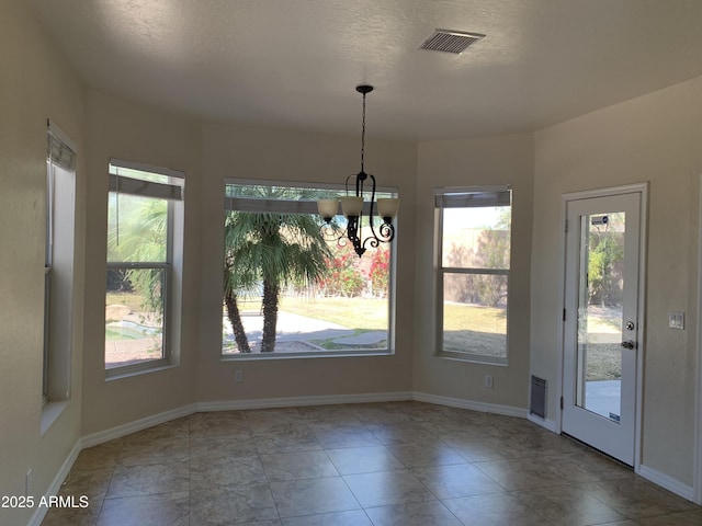 unfurnished dining area with an inviting chandelier, baseboards, and visible vents