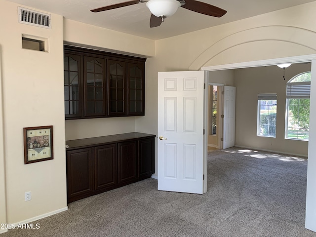 unfurnished room featuring light carpet, baseboards, visible vents, and a ceiling fan