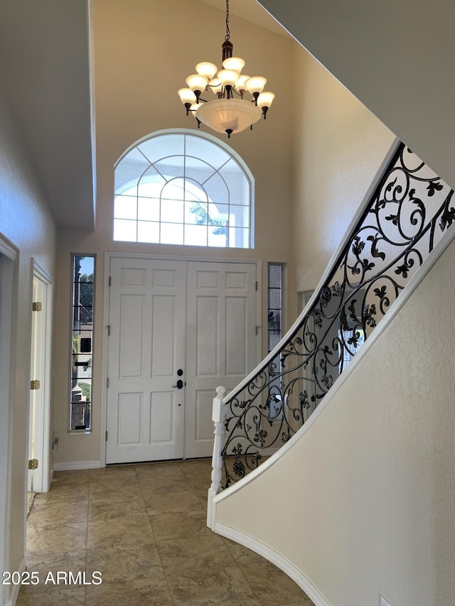 foyer featuring an inviting chandelier, a high ceiling, and stairway