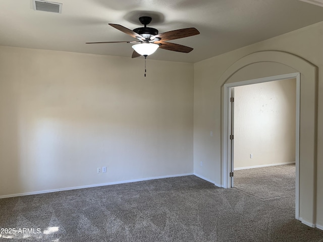 carpeted spare room with ceiling fan, visible vents, and baseboards