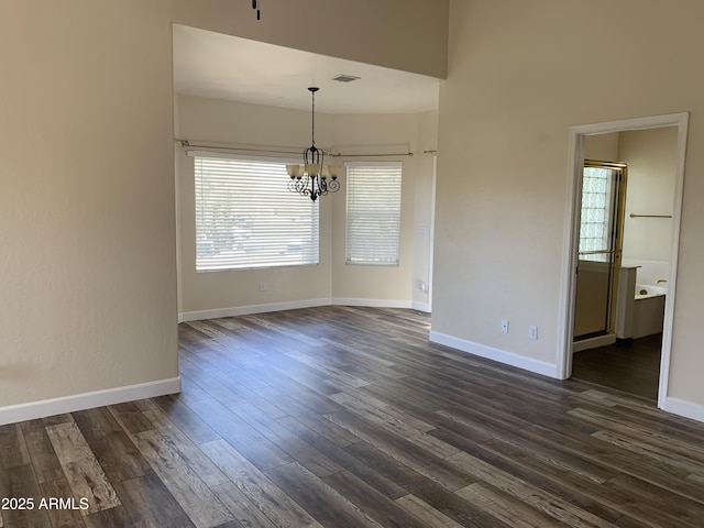 unfurnished dining area featuring dark wood-style floors, an inviting chandelier, visible vents, and baseboards