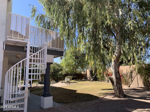 view of yard featuring fence, a patio, and stairs