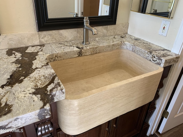 interior details featuring a sink and backsplash