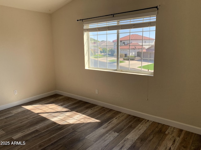 empty room featuring baseboards and wood finished floors