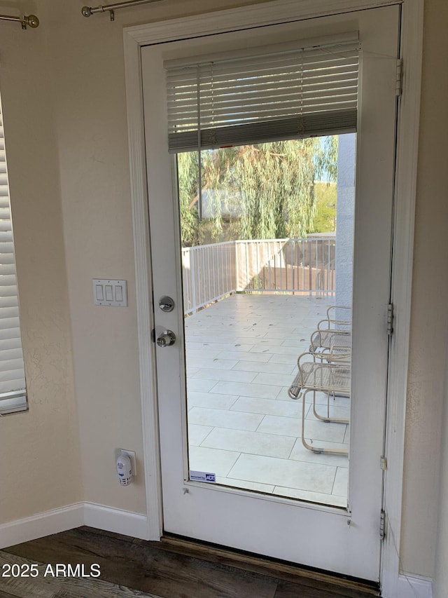 doorway to outside featuring baseboards, wood finished floors, and a healthy amount of sunlight