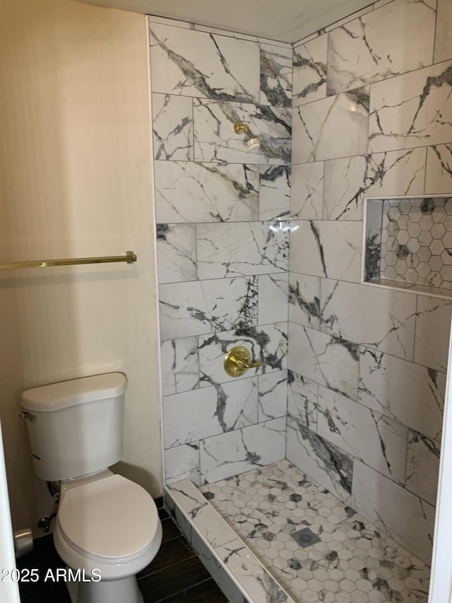 full bathroom featuring a stall shower and toilet
