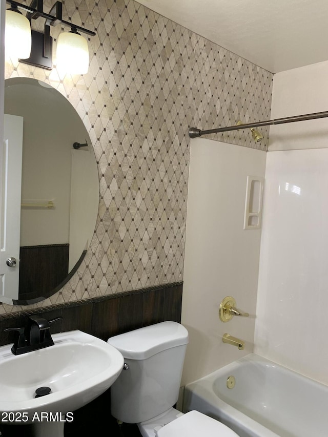 full bath featuring toilet, a sink, and shower / tub combination