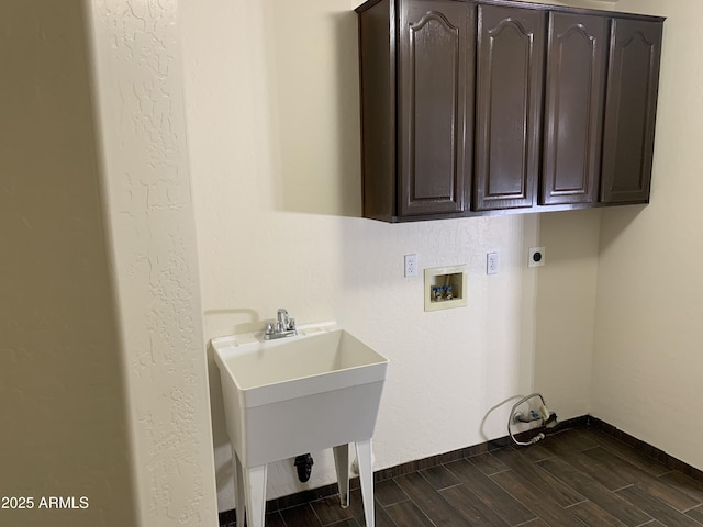 clothes washing area with washer hookup, wood finish floors, cabinet space, hookup for an electric dryer, and a sink