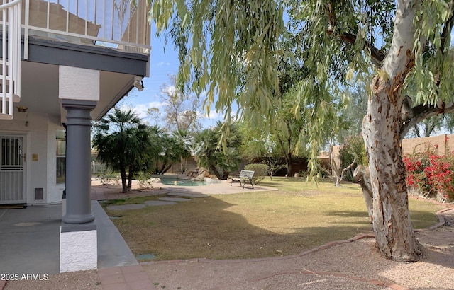 view of yard featuring a balcony, a patio area, a fenced backyard, and a fenced in pool
