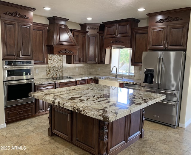 kitchen with dark brown cabinets, appliances with stainless steel finishes, decorative backsplash, and custom range hood