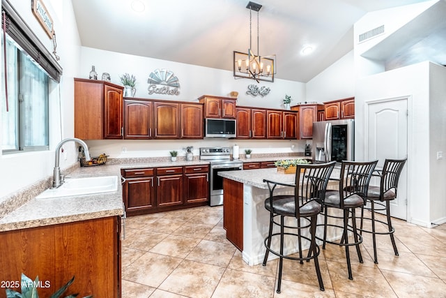 3511 W Allens Peak Dr, San Tan Valley, AZ 85144 - kitchen featuring appliances with stainless steel finishes, a sink, a kitchen breakfast bar, a chandelier, and light countertops