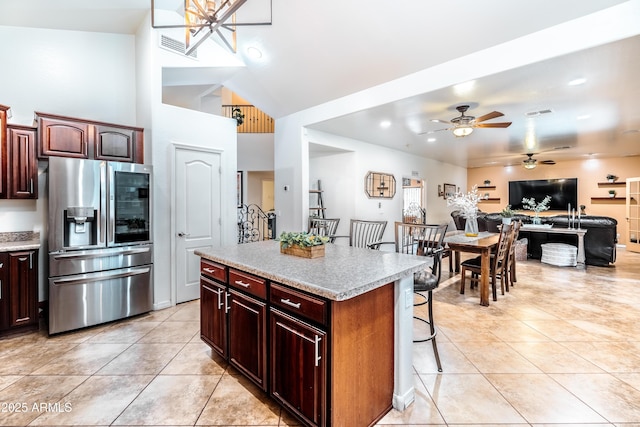 3511 W Allens Peak Dr, San Tan Valley, AZ 85144 - kitchen with stainless steel refrigerator with ice dispenser, ceiling fan, light tile patterned floors, light countertops, and a breakfast bar area