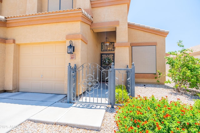 3511 W Allens Peak Dr, San Tan Valley, AZ 85144 - view of exterior entry featuring stucco siding, a gate, driveway, an attached garage, and a tiled roof