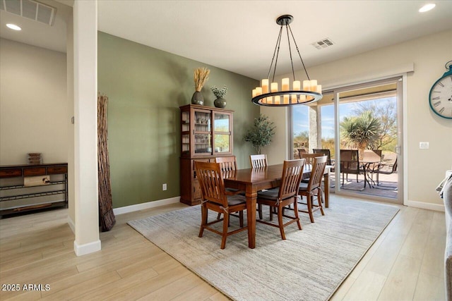 dining area featuring an inviting chandelier and light hardwood / wood-style flooring