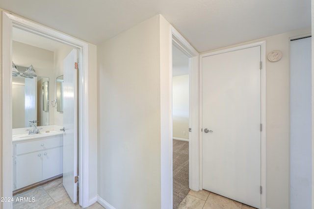 hallway with light tile patterned floors and sink