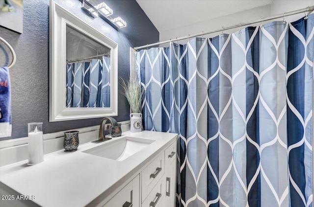 bathroom featuring lofted ceiling and vanity