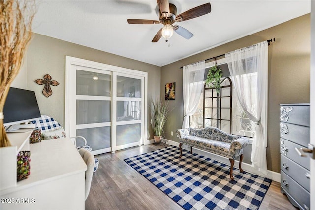 sitting room with wood-type flooring and ceiling fan