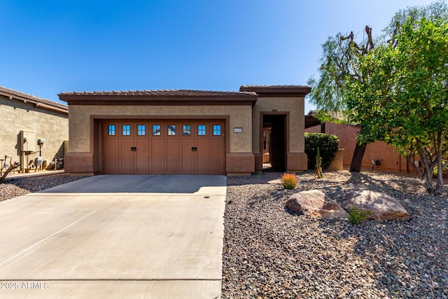 view of front of home featuring a garage, stucco siding, a tile roof, and concrete driveway