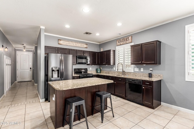 kitchen featuring light tile patterned floors, visible vents, dark brown cabinetry, a sink, and black appliances