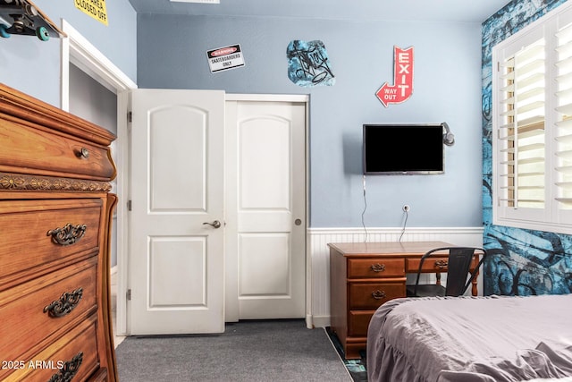 carpeted bedroom featuring wainscoting